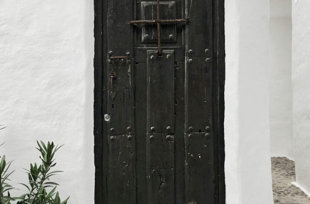 white building with closed black wooden door